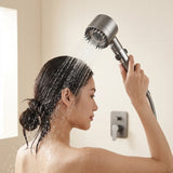 Mujer usando el cabezal de ducha en la ducha