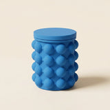 Cubetera de silicona azul para hielo con tapa puesta, fondo crema