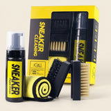 Kit de limpieza de zapatos completo: botella spray, caja, paño amarillo y dos cepillos de mango negro, fondo crema
