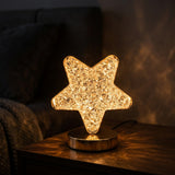 Lampara estrella de cristal encendida en ambiente oscuro mostrando el efecto de luces LED