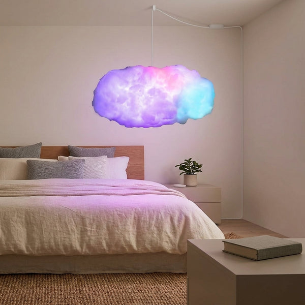 Lámpara nube encendida con colores RGB sobre una cama en un dormitorio real de noche