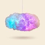 Lampara nube RGB encendida en tonos azul y purpura, fondo crema