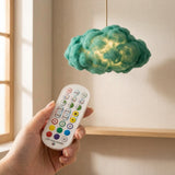 Mano sosteniendo el control remoto correcto de la lampara nube encendida en color verde esmeralda