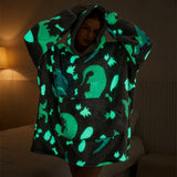 Poleron con estampado de dinosaurios brillando en la oscuridad, efecto glow in the dark verde turquesa, persona usandolo de noche
